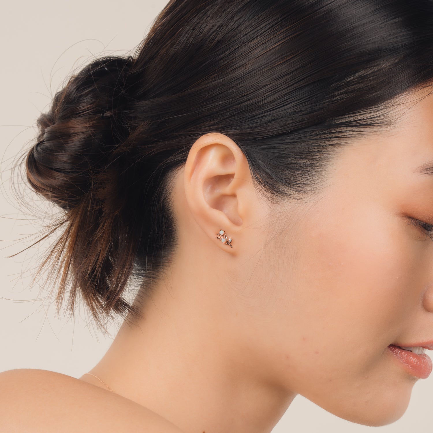 Fine and dainty studs. Model is wearing solid rose gold earrings set with opals and conflict free diamonds