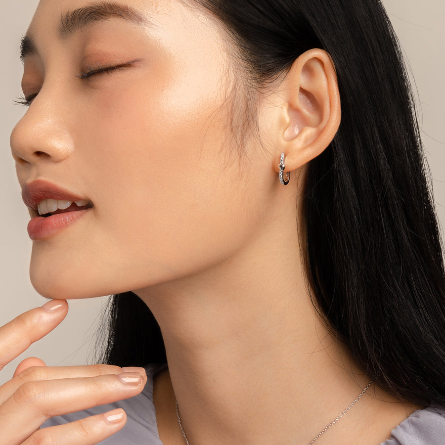Model wears charming and dainty huggies in 925 silver with cubic zirconia.