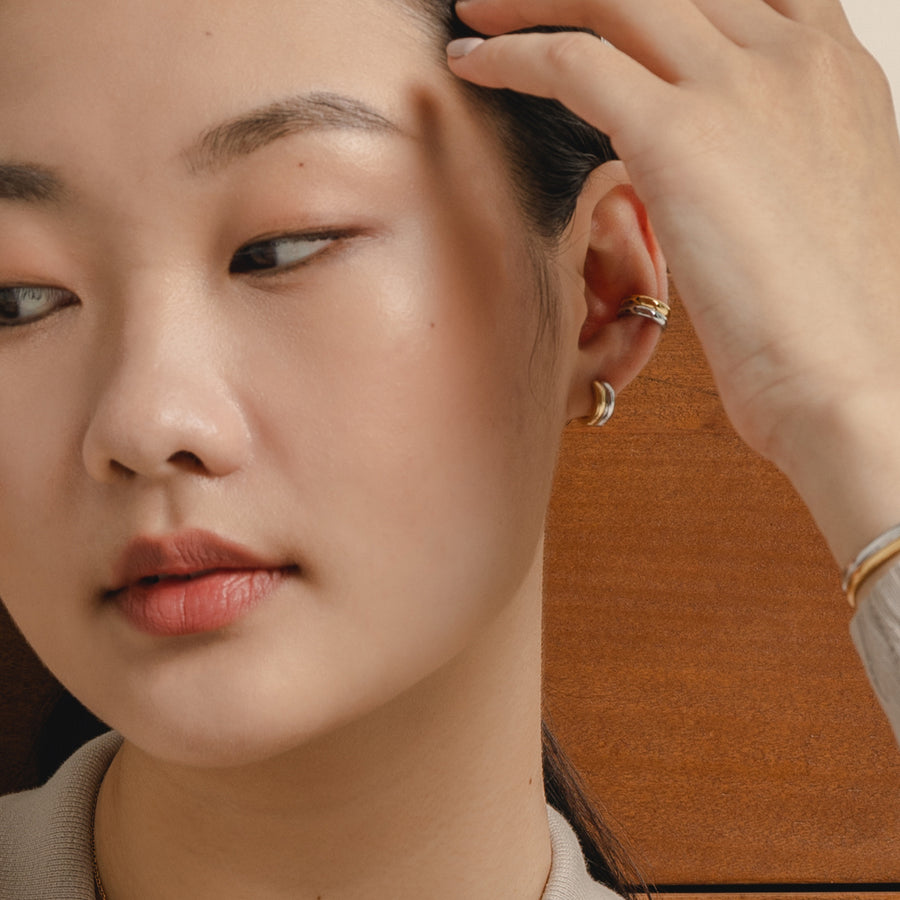 Model is wearing minimalist and sleek ear cuff in 925 silver.
