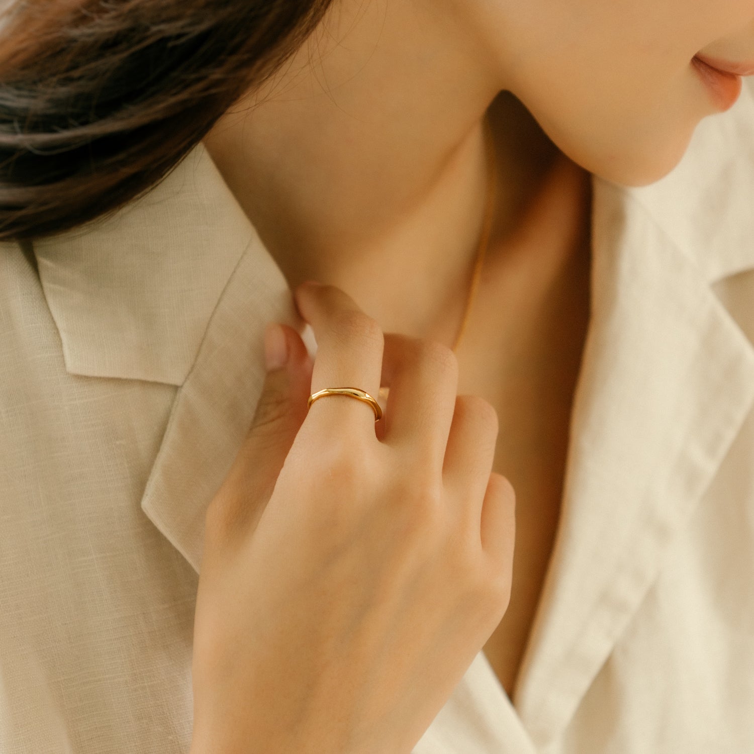 Model wears gold elegant and minimalist ring. 