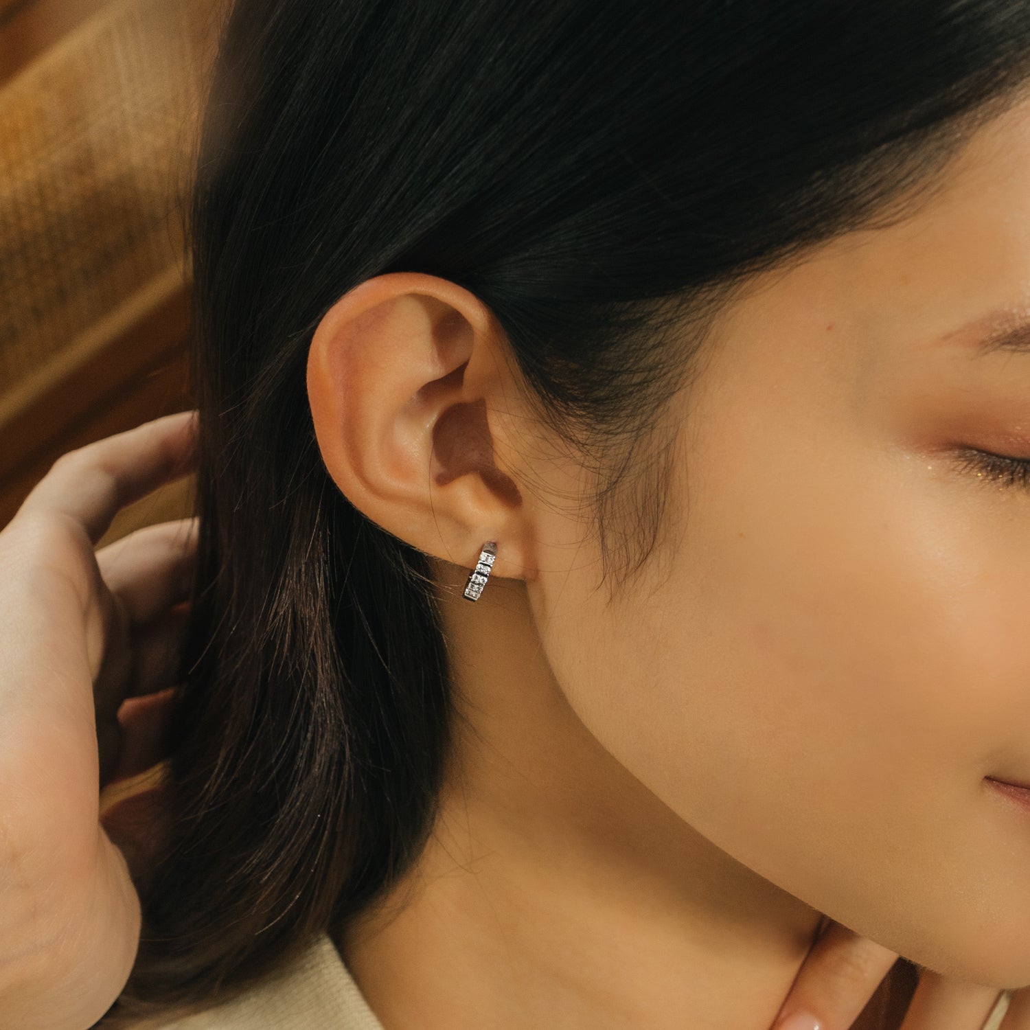 Timeless and elegant earrings. Model wears 925 silver huggies set with  cubic zirconia stones. 