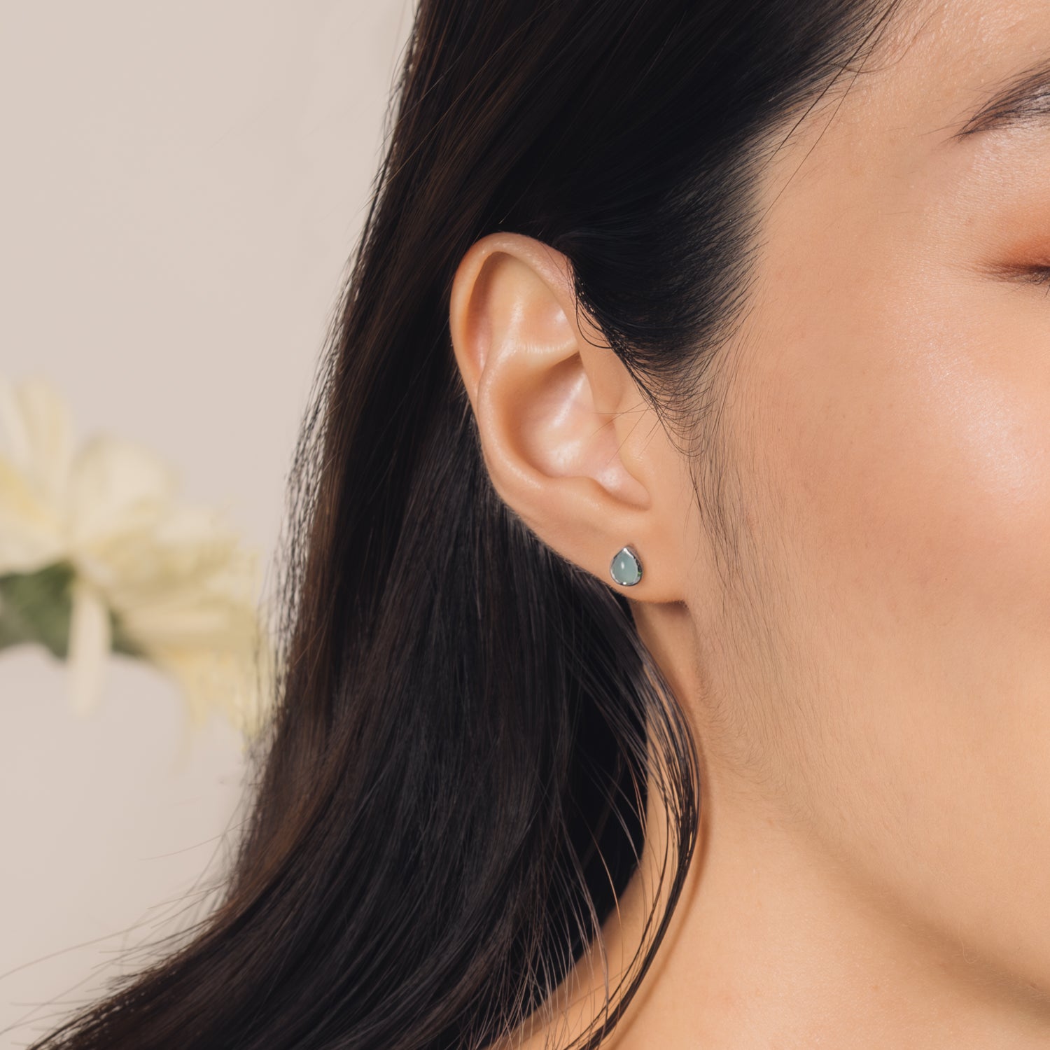 Fine and dainty studs. Model is wearing solid white gold earrings set with chalcedony gemstones