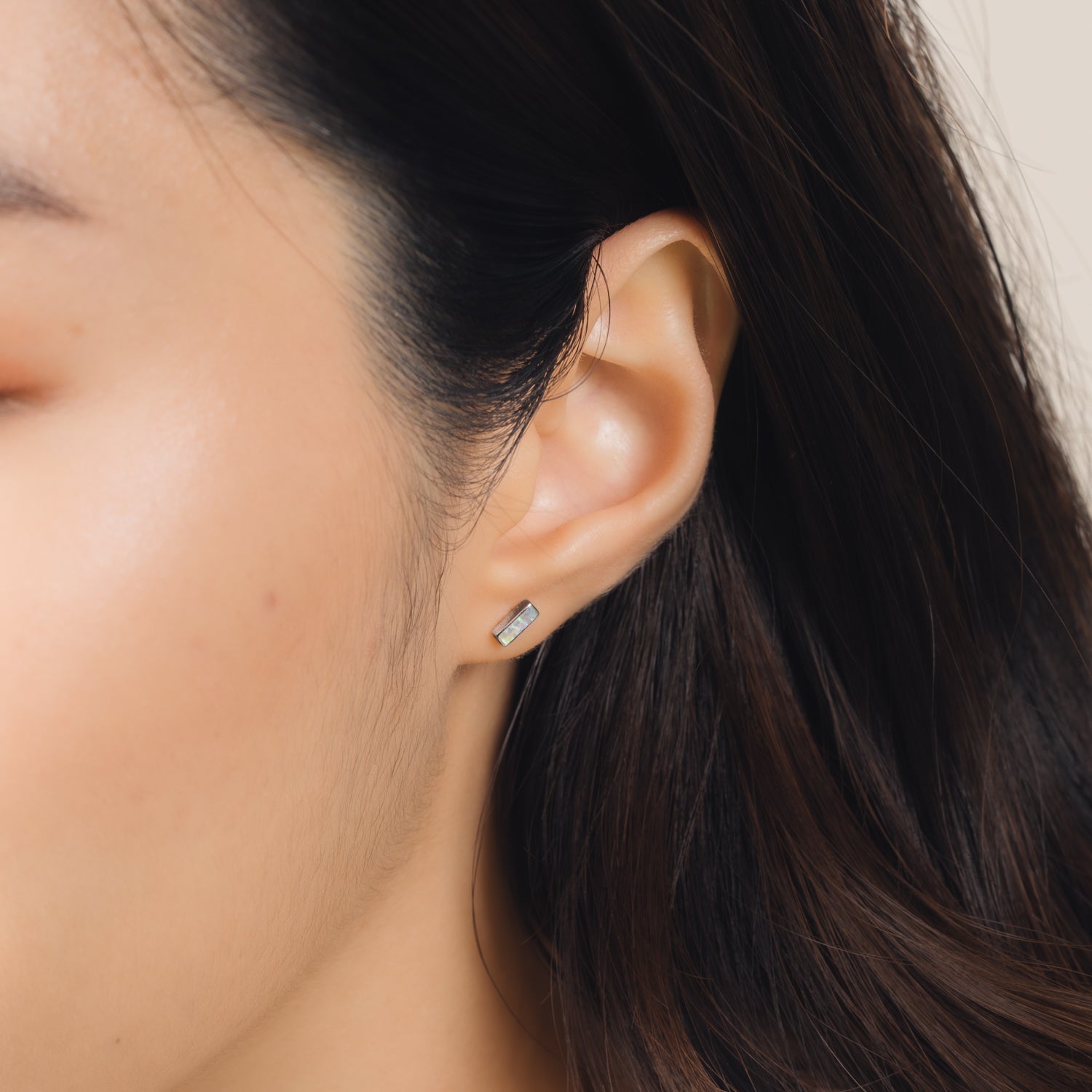 Fine and dainty studs. Model is wearing solid white gold earrings set with opal gemstones