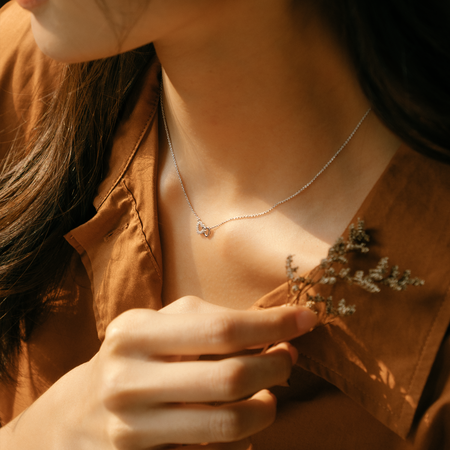 Model is wearing elegant and dainty necklace with cubic zirconia stones in silver.