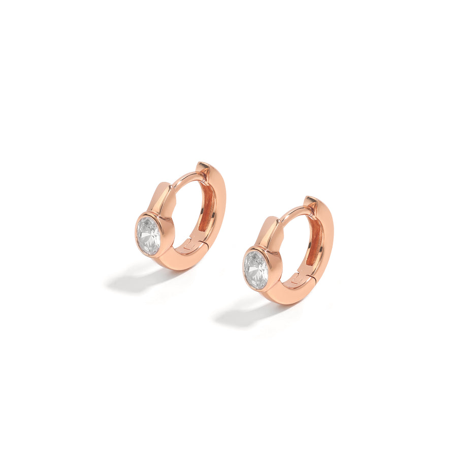 Minimalist and dainty earrings. Rose gold huggies set with cubic zirconia stones.