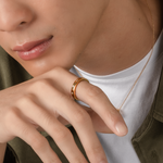 Model is wearing elegant and minimalist ring in gold, set with cubic zirconia stones.