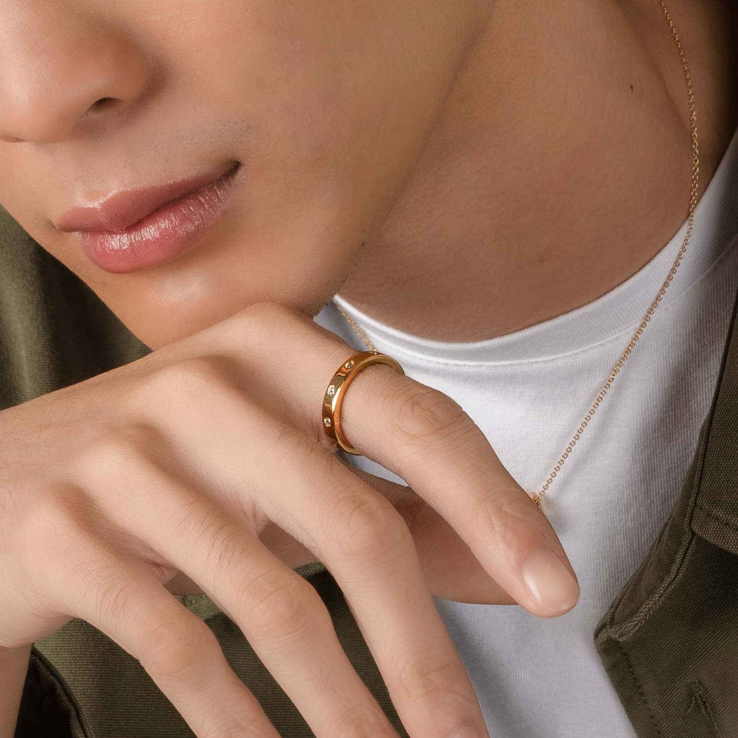 Model is wearing elegant and minimalist ring in gold, set with cubic zirconia stones.