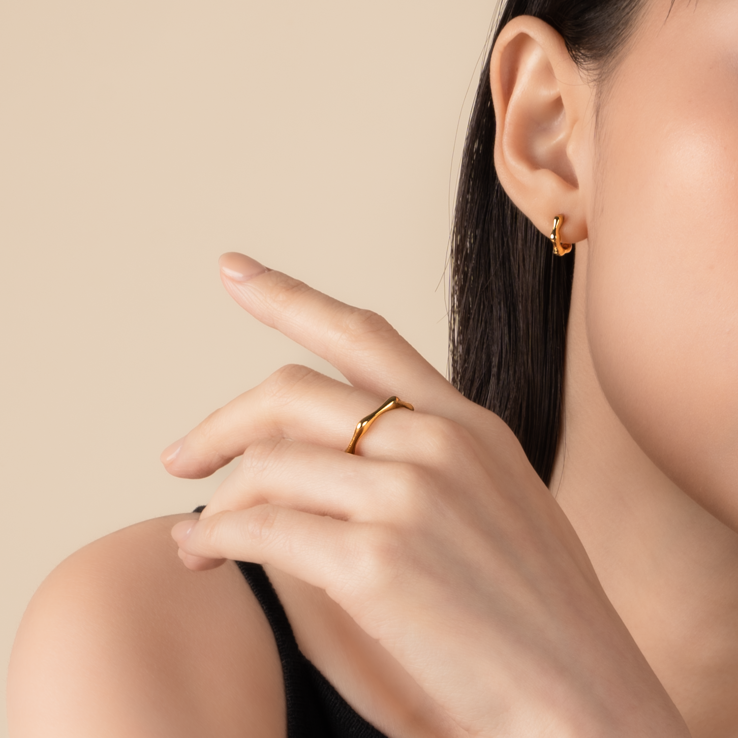 Model is wearing minimalist and sleek ring in gold.