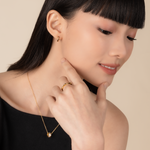 Model is wearing minimalist and sleek ring in gold.