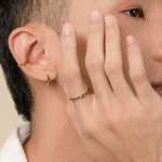 Model is wearing minimalist and sleek ring in gold.