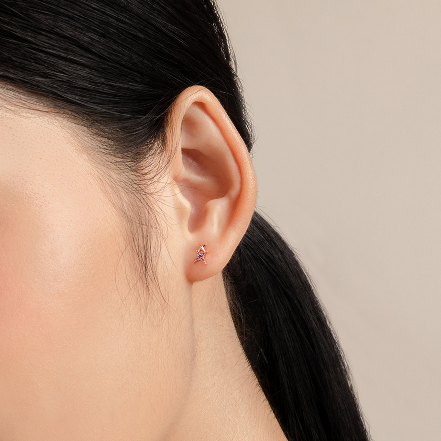 Simple and dainty earrings. Model wears rose gold studs set with cubic zirconia stones.