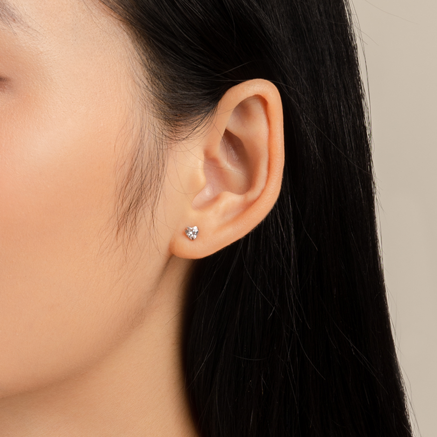 Model wears delicate and dainty studs in rose gold with cubic zirconia.