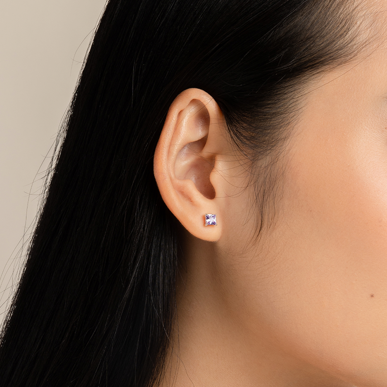 Model wears simple and minimalist studs with purple cubic zirconia in 925 silver.