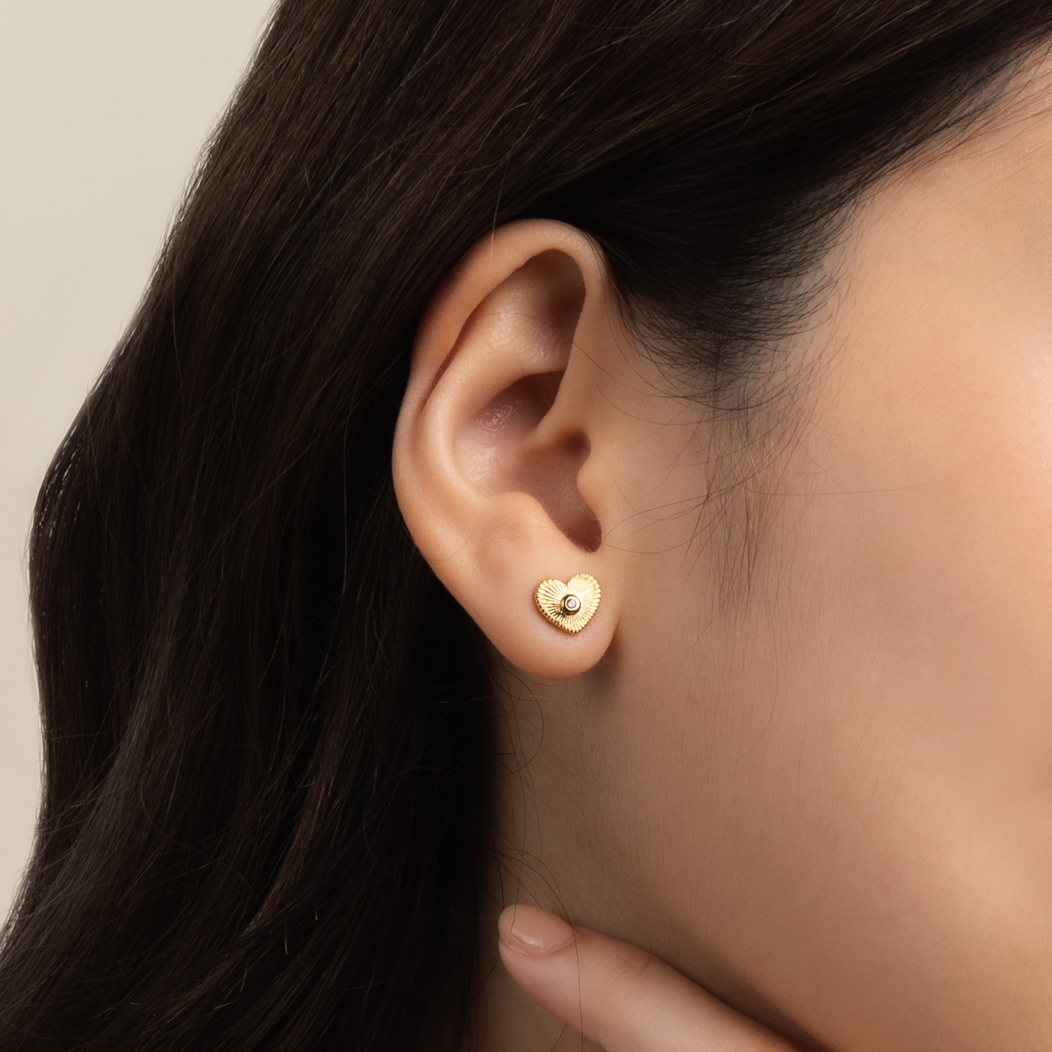 Model is wearing charming and romantic heart shaped earrings in gold with cubic zirconia 