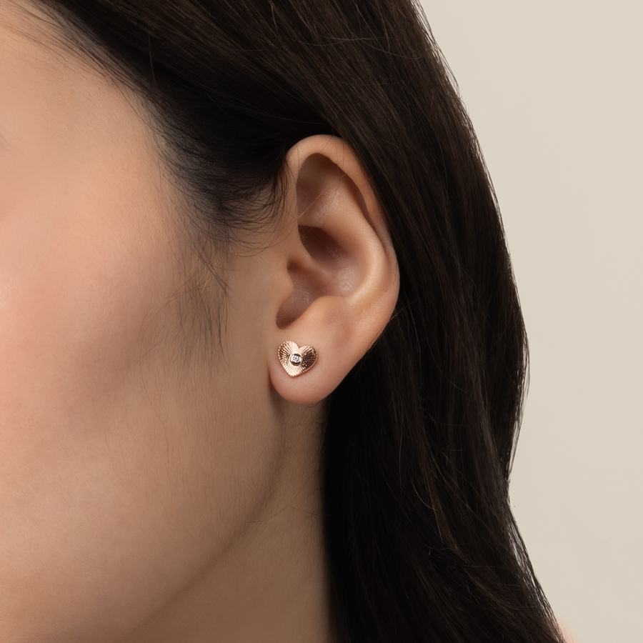 Model is wearing charming and romantic heart shaped earrings in rose gold with cubic zirconia 