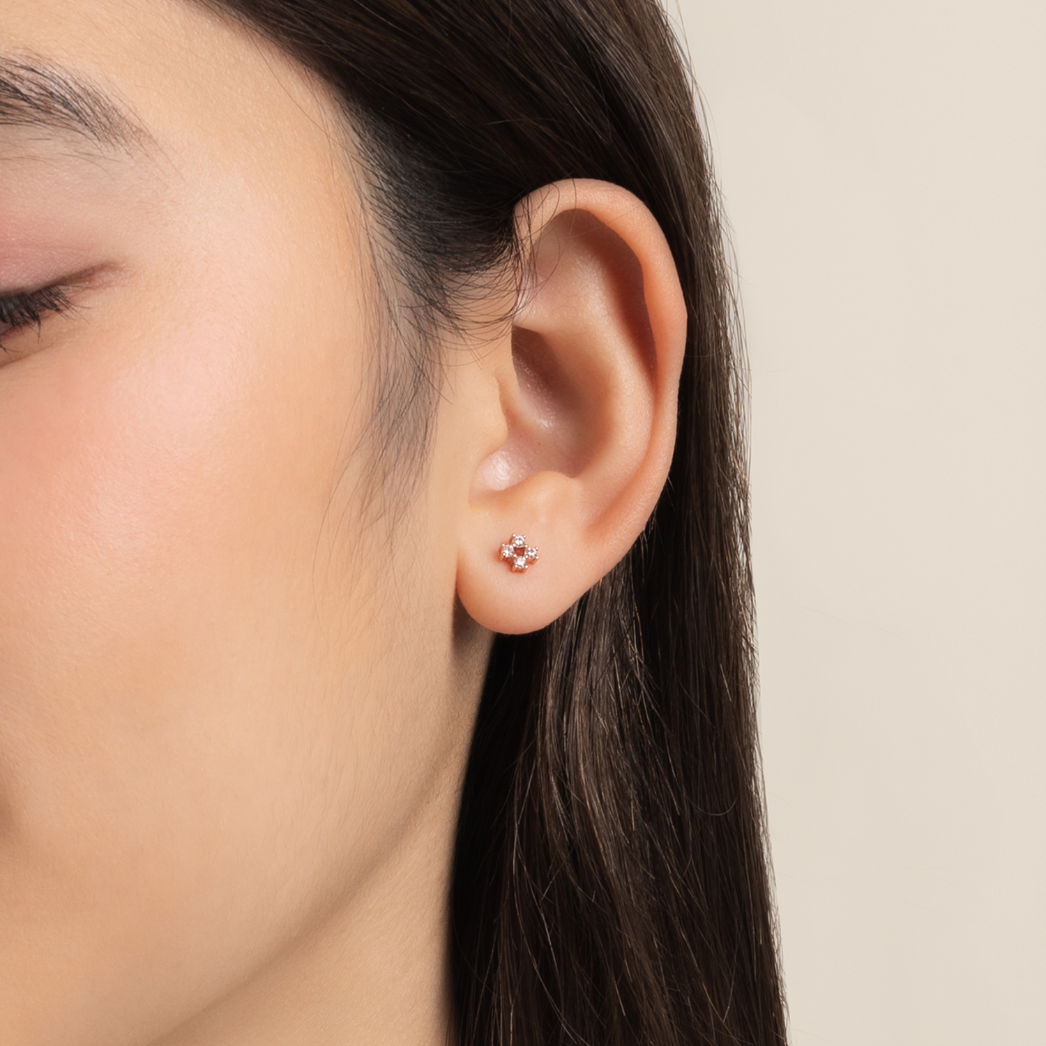 Model is wearing elegant and dainty earrings in rose gold with cubic zirconia