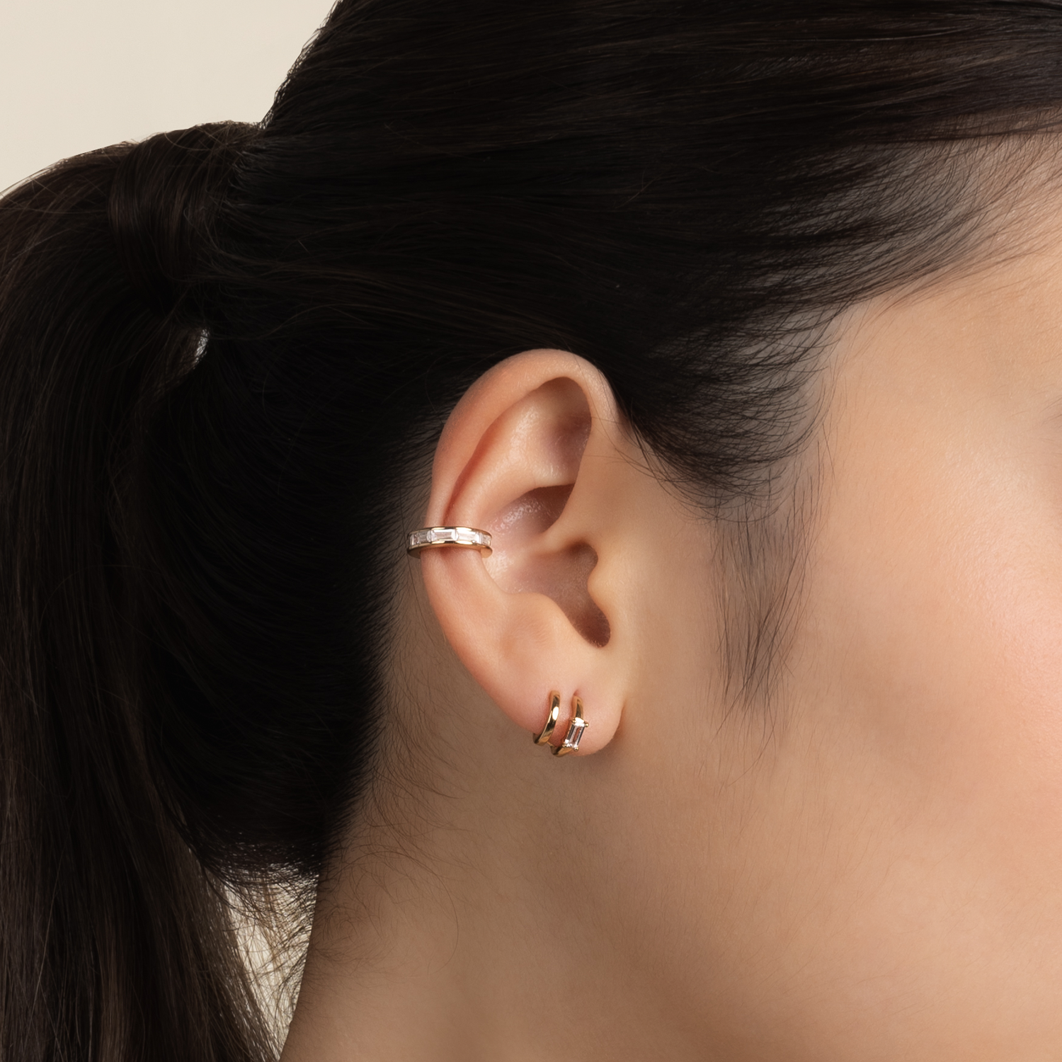 Model wears minimalist and classic ear cuff in gold with cubic zirconia