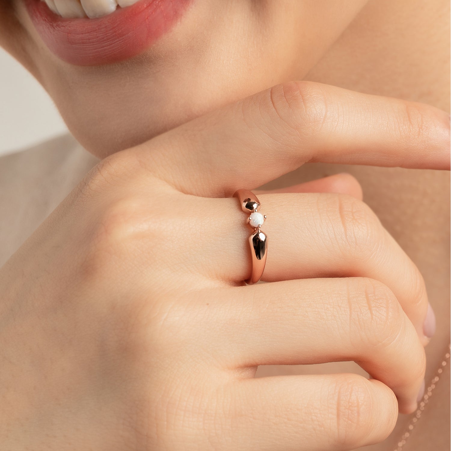 Model wears elegant and minimalist rose gold ring set with opals.