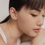 Model wears clean and minimalist huggies in rose gold.