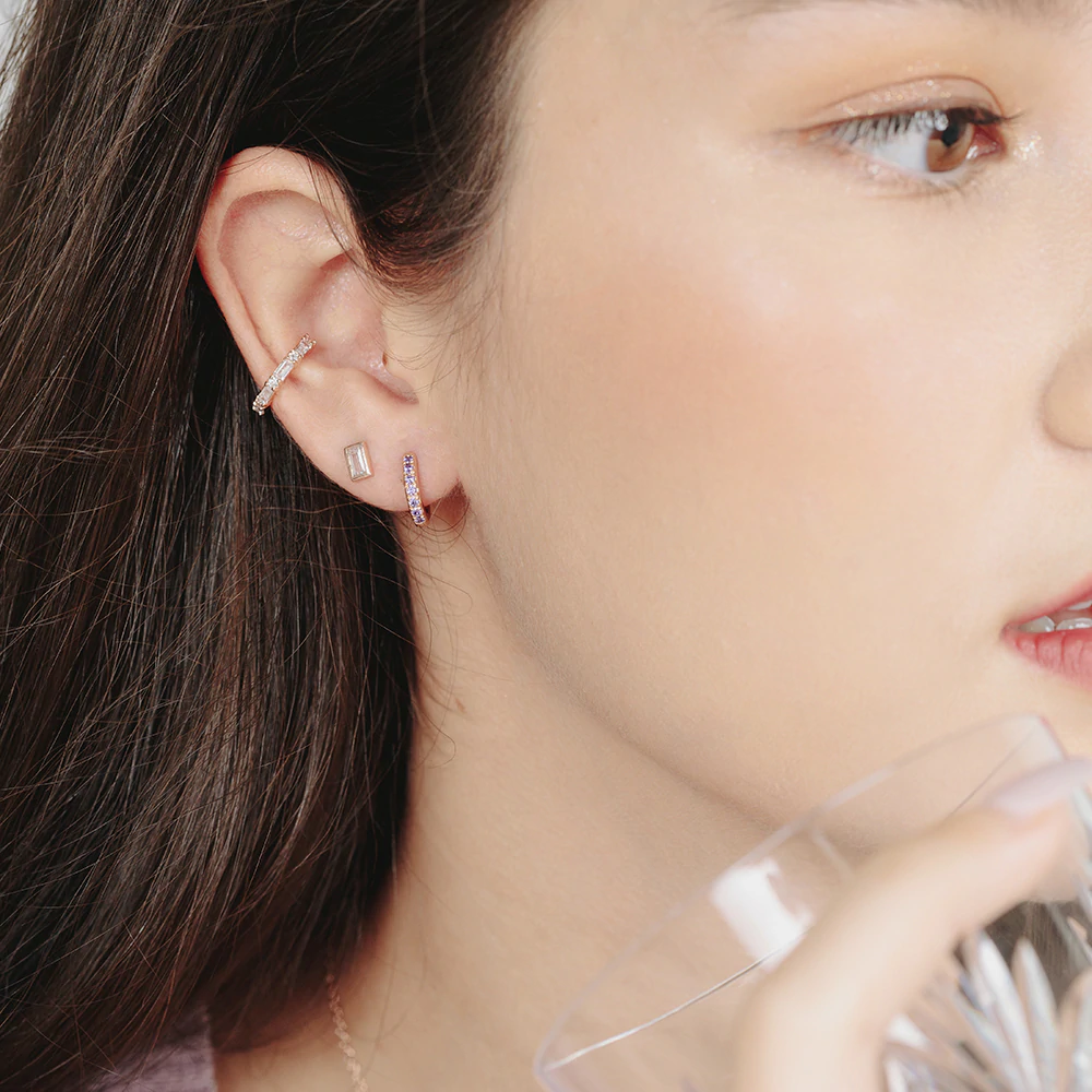 Model wears dainty and minimalist studs earrings in rose gold with cubic zirconia